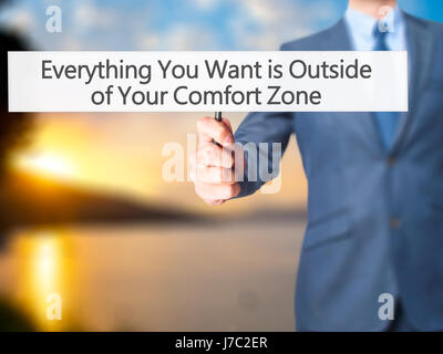 Alles, was Sie wollen ist außerhalb von Your Comfort Zone - Geschäftsmann Hand mit Schild. Wirtschaft, Technologie, Internet-Konzept. Stock Foto Stockfoto