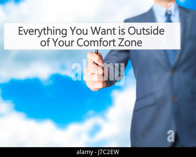 Alles, was Sie wollen ist außerhalb von Your Comfort Zone - Geschäftsmann Hand mit Schild. Wirtschaft, Technologie, Internet-Konzept. Stock Foto Stockfoto