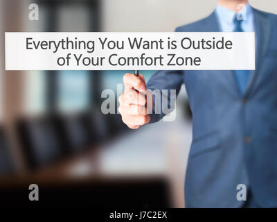 Alles, was Sie wollen ist außerhalb von Your Comfort Zone - Geschäftsmann Hand mit Schild. Wirtschaft, Technologie, Internet-Konzept. Stock Foto Stockfoto