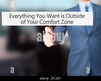 Alles, was Sie wollen ist außerhalb von Your Comfort Zone - Geschäftsmann Hand mit Schild. Wirtschaft, Technologie, Internet-Konzept. Stock Foto Stockfoto