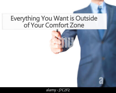 Alles, was Sie wollen ist außerhalb von Your Comfort Zone - Geschäftsmann Hand mit Schild. Wirtschaft, Technologie, Internet-Konzept. Stock Foto Stockfoto