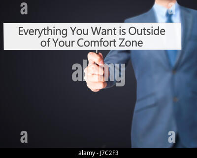 Alles, was Sie wollen ist außerhalb von Your Comfort Zone - Geschäftsmann Hand mit Schild. Wirtschaft, Technologie, Internet-Konzept. Stock Foto Stockfoto