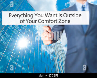 Alles, was Sie wollen ist außerhalb von Your Comfort Zone - Geschäftsmann Hand mit Schild. Wirtschaft, Technologie, Internet-Konzept. Stock Foto Stockfoto