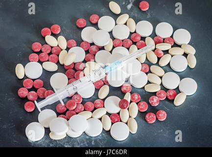 Rot, weiß, gelb Medikamente Pillen mit Spritze, Pulver, Haufen, medizinische, homöopathische, schwarzer Hintergrund, hautnah. Stockfoto