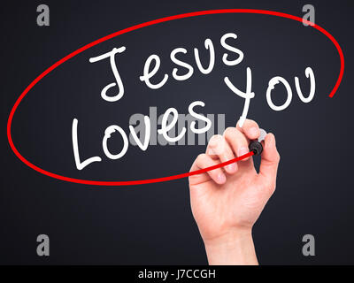 Hand des Menschen Jesus Loves You mit schwarzem Filzstift auf Bildschirm zu schreiben. Isoliert auf schwarz. Religion, Technik, Internet-Konzept. Stock Bild Stockfoto