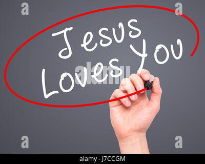 Hand des Menschen Jesus Loves You mit schwarzem Filzstift auf Bildschirm zu schreiben. Isoliert auf grau. Religion, Technik, Internet-Konzept. Stock Bild Stockfoto