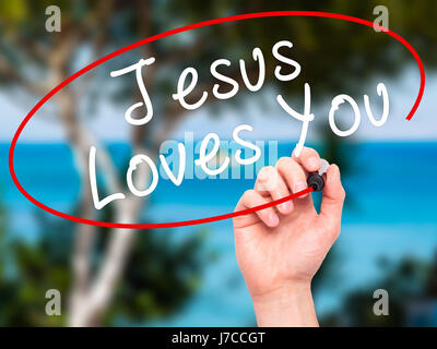 Hand des Menschen Jesus Loves You mit schwarzem Filzstift auf Bildschirm zu schreiben. Isoliert auf Natur. Religion, Technik, Internet-Konzept. Stock Bild Stockfoto