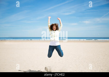 Froh, dass Mitte springen am Strand verrückt nach Urlaub im Alter von Stockfoto
