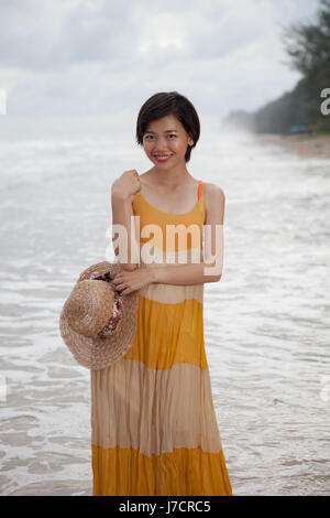Porträt der jungen Asiatin lange Kleid mit lächelnden Gesicht stehen am Strand relaxen emotion Stockfoto