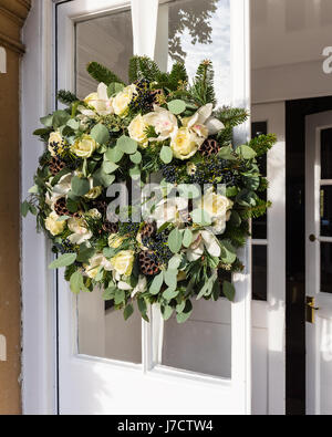 Eine schöne handgemachte Kranz aus verdrehten Weide, weißen Rosen und Lotusblumen an Eingangstür Stockfoto