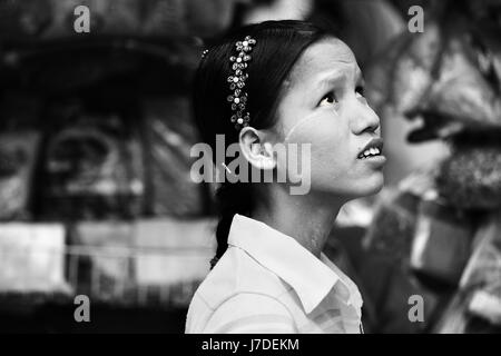 Schöne kontrastreiche schwarz-weiß-Foto von Myanmar Mädchen suchen Skywards in Monochrom. Burmesische Mädchen trägt Alice Band in den Haaren in Yangon Stockfoto