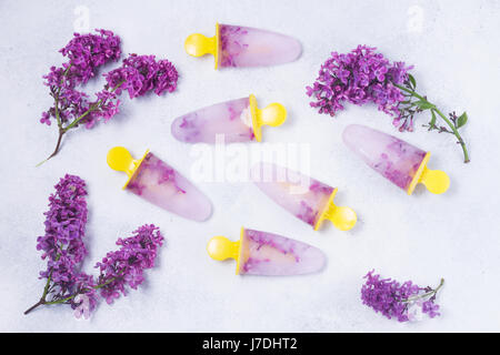 Eis am Stiel mit lila Blumen Stockfoto