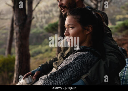 Junge asiatische Frau sitzen im Freien mit ihrem Freund. Junges Paar nach Wanderung ausruhen. Stockfoto