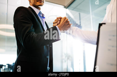 Zwei Geschäftsmann Hände schütteln im Amt. Nahaufnahme des Handshakes nach einem erfolgreichen Geschäftsabschluss. Stockfoto