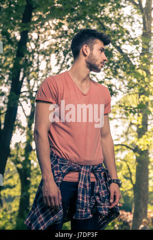 ein junger Erwachsener Mann wegsehen, nur Natur Natur Bäume Parken Stockfoto