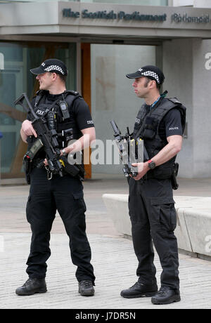 Bewaffnete Polizisten patrouillieren vor dem schottischen Parlamentsgebäude in Holyrood, Edinburgh, nachdem Scotland Yard angekündigt hatte, dass bewaffnete Truppen eingesetzt werden, um wichtige Orte wie den Buckingham Palace, die Downing Street, den Palace of Westminster und Botschaften zu bewachen. Stockfoto