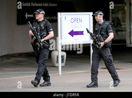 Bewaffnete Polizisten auf Patrouille außerhalb des schottischen Parlamentsgebäudes in Holyrood, Edinburgh, nach Scotland Yard bewaffneten Truppen bereitgestellt werden angekündigt, um "Schlüsselpositionen" wie der Buckingham Palace, Downing Street, der Palace of Westminster und Botschaften zu schützen. Stockfoto