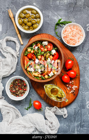 Frühling Gemüsesalat mit Rucola, Cherry-Tomaten, Kichererbsen, Oliven und Feta-Käse. Gesunde, vegane, Detox Lebensmittel. Ansicht von oben Stockfoto