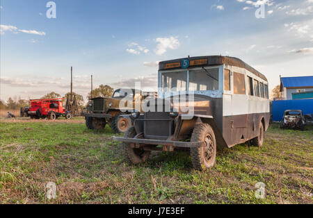 Vintage Retro Bus auf dem Gras auf dem Hintergrund der Oldtimer Lkw Stockfoto