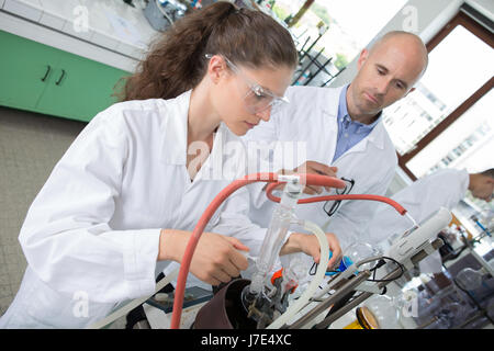 Schüler und Lehrer gemeinsam auf einen Roboterarm Stockfoto
