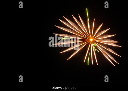 Ein Stoß von Orange und Grün Feuerwerk in den Nachthimmel. Stockfoto