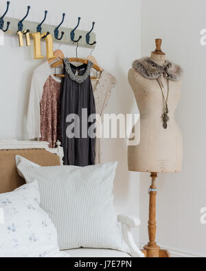 Elegante Schaufensterpuppe im Schlafzimmer mit rustikaler Kleiderhaken und Kissen aus Kohl & Rosen Stockfoto