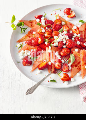 Melonen-Carpaccio mit Erdbeeren und Ziegenkäse Stockfoto