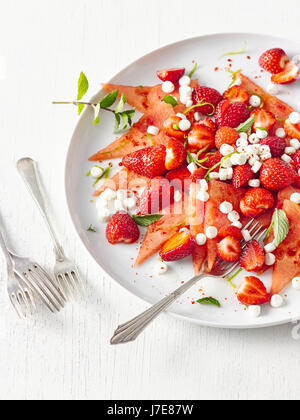 Melonen-Carpaccio mit Erdbeeren und Ziegenkäse Stockfoto