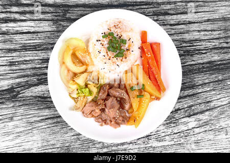 Thai Jasminreis im amerikanischen koreanischen Stil, Reis mit geschnittenem Schweinefleisch Steak, in Scheiben geschnittenen Karotten, Kartoffeln, Zwiebeln und gebratener Kohl gekrönt Sesames und Schalotten. Stockfoto