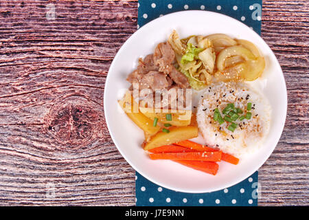 Thai Jasminreis im amerikanischen koreanischen Stil, Reis mit geschnittenem Schweinefleisch Steak, in Scheiben geschnittenen Karotten, Kartoffeln, Zwiebeln und gebratener Kohl gekrönt Sesames und Schalotten. Stockfoto