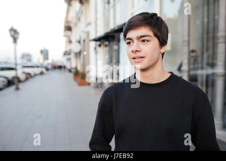 Porträt von Ernst junger Mann mit schwarzen Pullover auf der Straße in der Nähe von Cafés Stockfoto