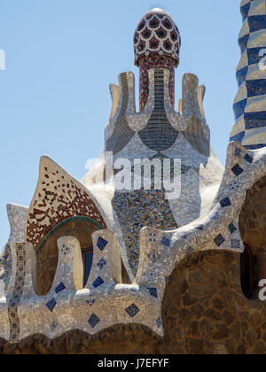 Ein Pilz geformten Turm und reich verzierten Mosaik gefliest Dach eines Hauses in Antoni Gaudis Park Güell, Barcelona, Spanien. Stockfoto