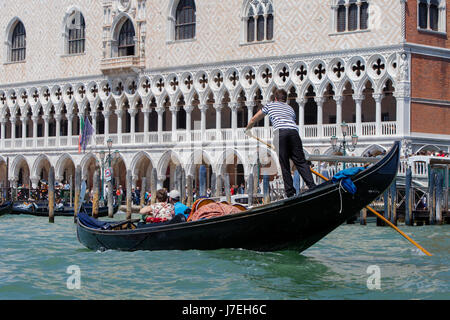 Gondoliere und das Paar vor dem Dogenpalast in Venedig, Italien Stockfoto