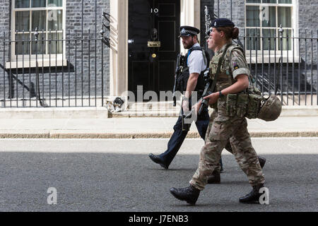 London, UK. 24. Mai 2017. Ein Polizist und zwei weiblichen Soldaten Fuß vorbei an der Haustür von Nr. 10 Downing Street, Amt des Premierministers. Foto: Lebendige Bilder/Alamy Live-Nachrichten Stockfoto