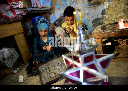 (170524)--Kairo, 24. Mai 2017 (Xinhua)--Hussein Sayyid Kinder machen traditionelle handgefertigte Laternen in ihres Vaters Werkstatt in Kairo, Ägypten, am 20. Mai 2017. Befindet sich in einem alten Gebäude in einer Straße voller Workshops in Al-Qalaa, die "die Zitadelle" auf Arabisch bedeutet unter Bezugnahme auf Kairos Saladin-Zitadelle, produziert von Sayyid Workshop bunte handgemachte Glas und Metall-Laternen in verschiedenen Größen, auf Arabisch als "Fanoos", angezeigt auf steht außerhalb der Werkstatt bekannt. Traditionelle handgefertigte Laternen dienen in der Regel als Dekoration in Ägypten während der jährlichen Monat Ramadan. (Xinhua/Zhao Dingzhe Stockfoto