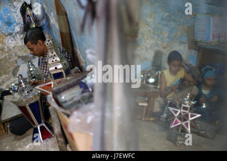 (170524)--Kairo, 24. Mai 2017 (Xinhua)--Hussein Sayyid (L) und seine Kinder machen traditionelle handgefertigte Laternen in seiner Werkstatt in Kairo, Ägypten, am 20. Mai 2017. Befindet sich in einem alten Gebäude in einer Straße voller Workshops in Al-Qalaa, die "die Zitadelle" auf Arabisch bedeutet unter Bezugnahme auf Kairos Saladin-Zitadelle, produziert von Sayyid Workshop bunte handgemachte Glas und Metall-Laternen in verschiedenen Größen, auf Arabisch als "Fanoos", angezeigt auf steht außerhalb der Werkstatt bekannt. Traditionelle handgefertigte Laternen dienen in der Regel als Dekoration in Ägypten während der jährlichen Monat Ramadan. (Xinhua/Ahmed Gomaa) Stockfoto