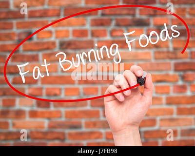 Hand des Mannes Fat Burning Foods mit schwarzem Filzstift auf Bildschirm zu schreiben. Isoliert auf Ziegel. Wirtschaft, Technologie, Internet-Konzept. Stock Foto Stockfoto