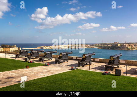 Batterie von Kanonen mit Blick auf Hafen in Upper Barrakka Gardens in Valletta, Malta Stockfoto