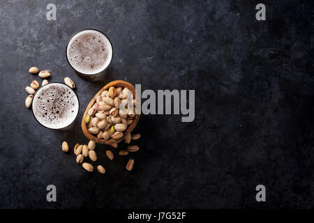 Lager-Bier und Snacks am Steintisch. Muttern. Draufsicht mit Textfreiraum Stockfoto