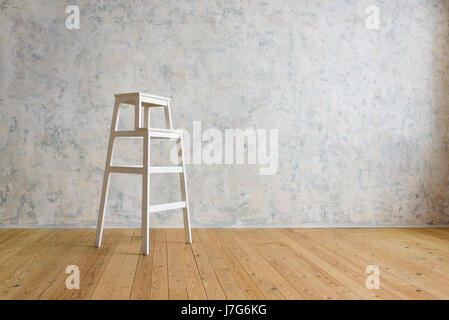 Holztreppe steht in einem Raum mit einer weißen Wand Stockfoto