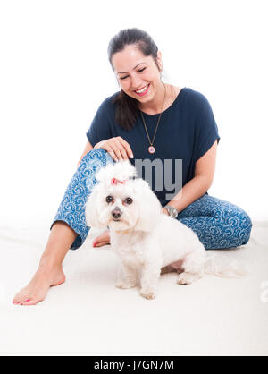 Lächelnde Frau mit ihrem flauschigen Hund isoliert auf weißem Hintergrund Stockfoto