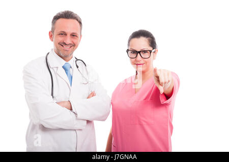 Schöne weibliche Krankenschwester in der Nähe von Arzt mit Stethoskop zeigt auf Sie mit Finger isoliert auf weißem Hintergrund Stockfoto