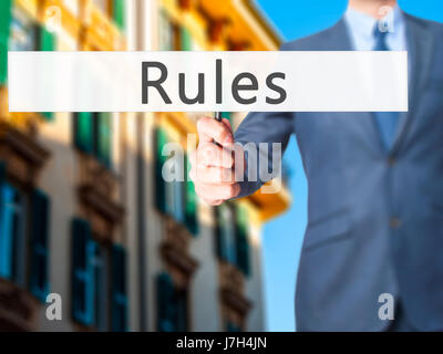 Regeln - Geschäftsmann Hand mit Schild. Wirtschaft, Technologie, Internet-Konzept. Stock Foto Stockfoto