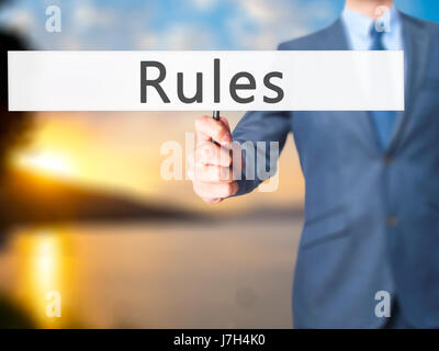 Regeln - Geschäftsmann Hand mit Schild. Wirtschaft, Technologie, Internet-Konzept. Stock Foto Stockfoto