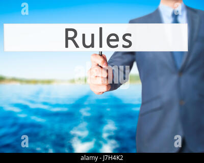 Regeln - Geschäftsmann Hand mit Schild. Wirtschaft, Technologie, Internet-Konzept. Stock Foto Stockfoto