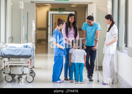 Junge asiatische indische Familie, Eltern und 2 Mädchen weibliche Kinder mit Frau Doktor und Krankenschwester in modernen Krankenhausflur Stockfoto