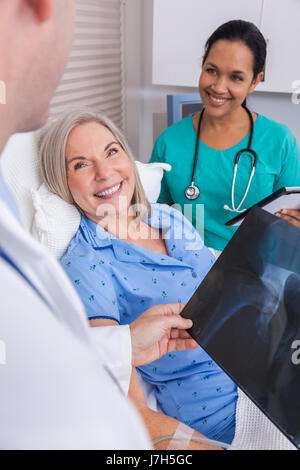 Beautiful senior Woman Patient erholt sich im Krankenhaus mit männlichen Arzt und Krankenschwester betrachten Hüftgelenkersatz Röntgen Stockfoto