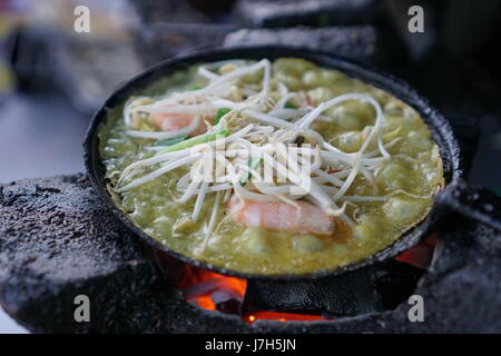 Bánh Xèo, eine vietnamesische Reis Krepp über Holzkohle gegart. Stockfoto