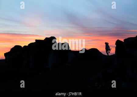 Lanzarote-Sonnenuntergang - eine Frau steht auf einem vulkanischen Felsen bei Sonnenuntergang, Lanzarote, Kanarische Inseln Europas. Konzept / konzeptionelle Bild Stockfoto