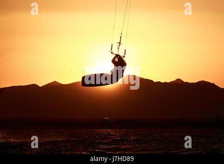 Kite Boarder Sportler mit Kite unter Sonnenuntergang Sonne, Freestyle Kiteboarding Reiter auf den Abend-Kite-Session, Sonnenuntergang im Meer, extreme watersports Stockfoto